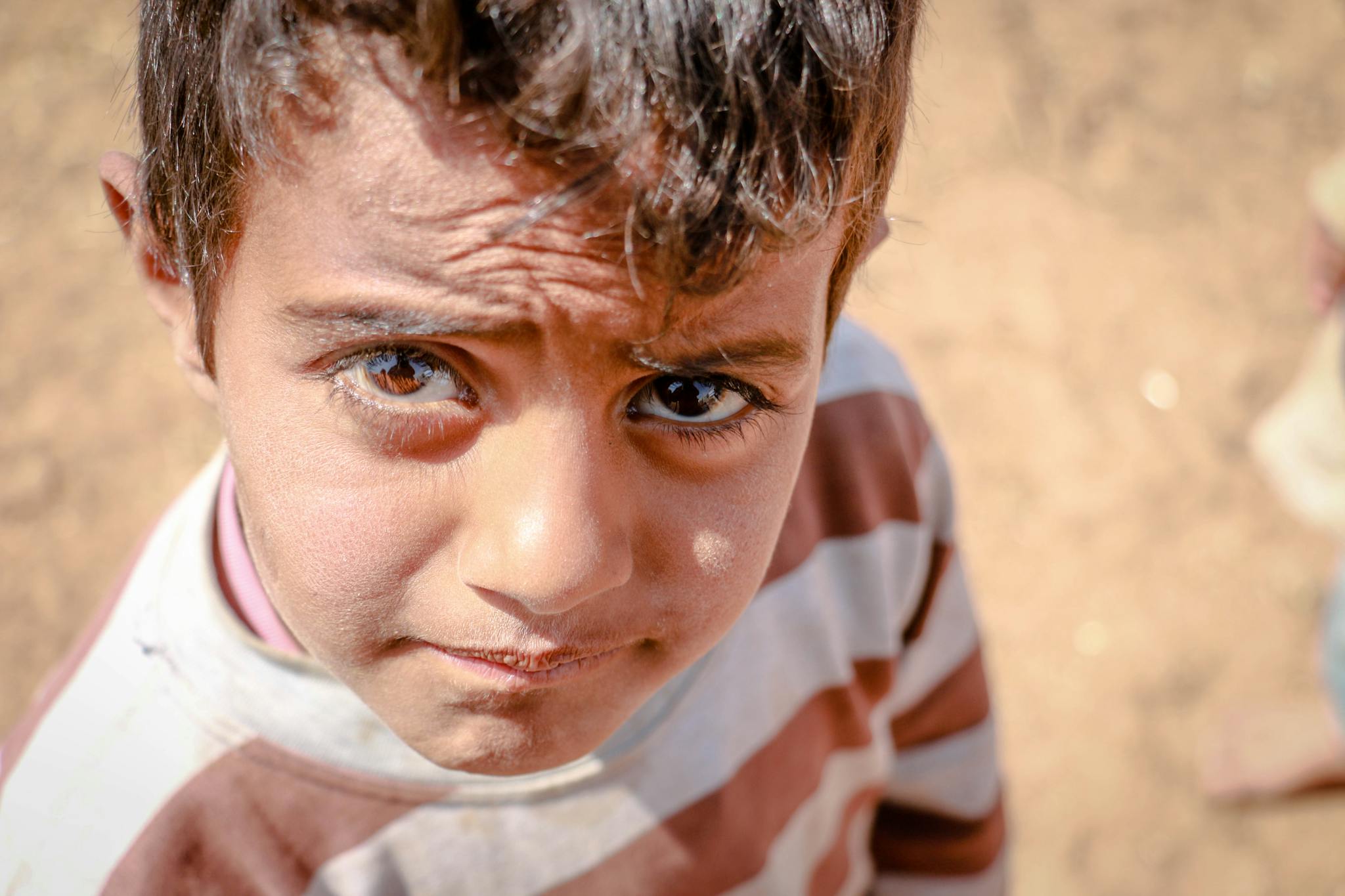 Close-up shot of a young boy in Idlib, capturing innocence in a crisis setting.